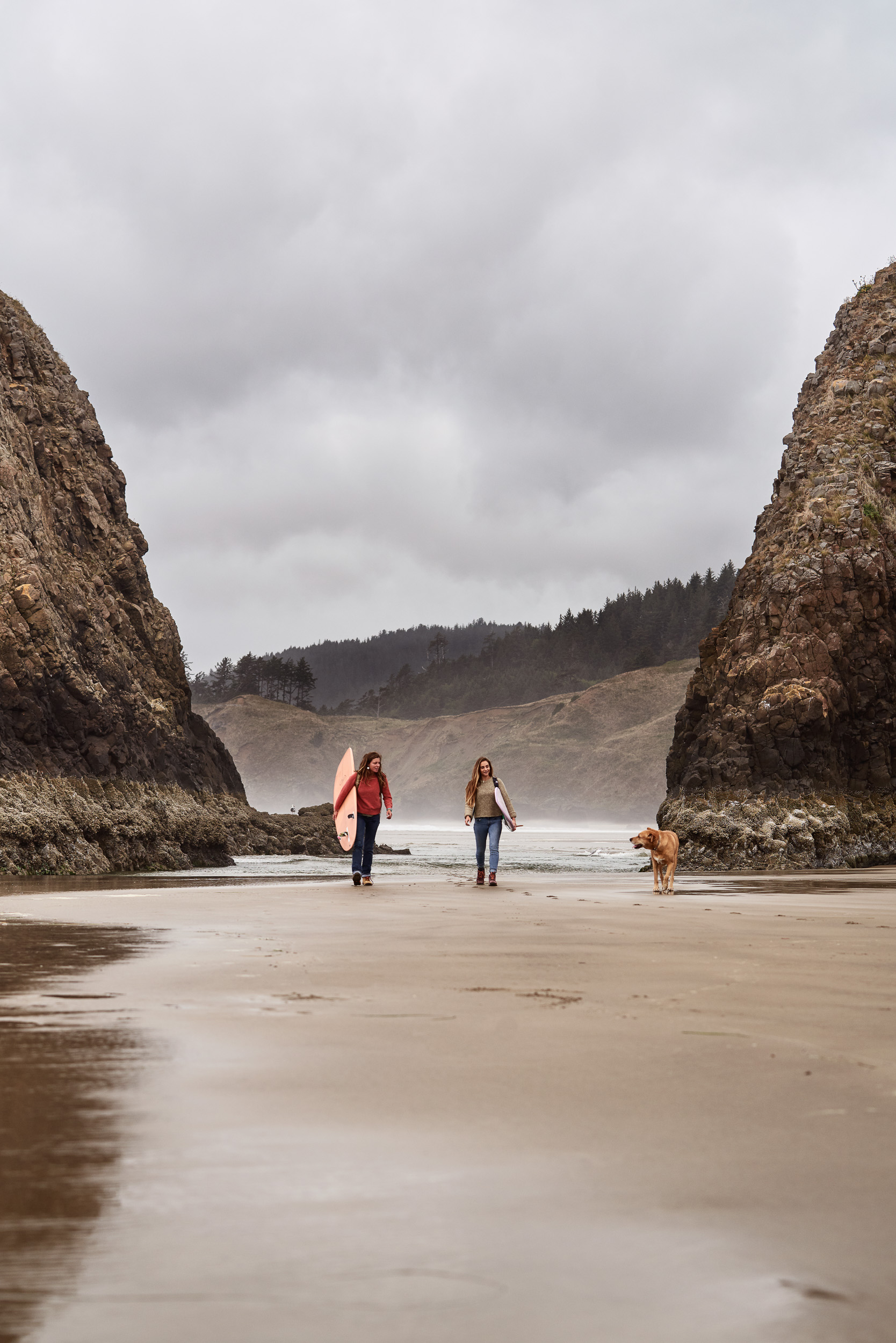Two women surfers walking on beach in Cannon Beach, OR wearing Danner Inquire boots