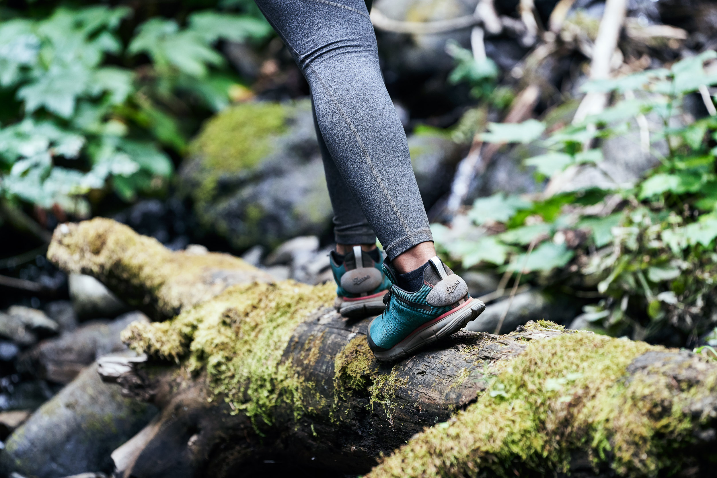 Women walking across log on the Pacific Crest Trail while wearing Danner 2650